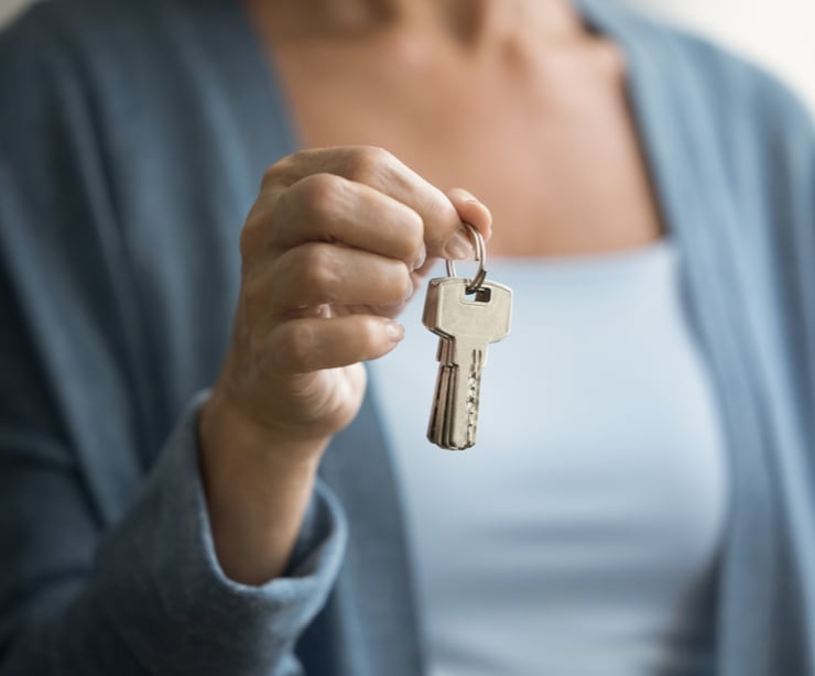 A woman holding up keys.